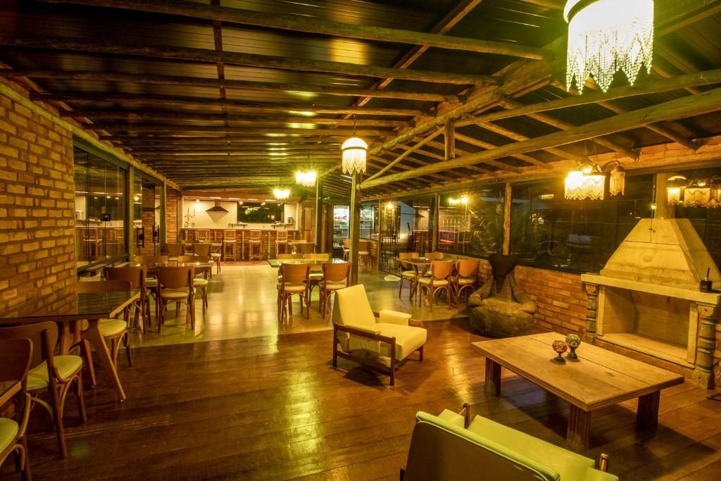Lounge e bar com madeira, tijolos e lareira